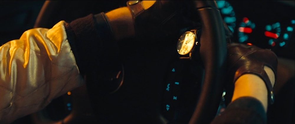 Ryan Gosling placing his luminous custom watch on a steering wheel in Drive