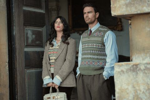 In-character production photograph of Eddie beside Susie, with a pale watch face exposed at his trouser pocket.