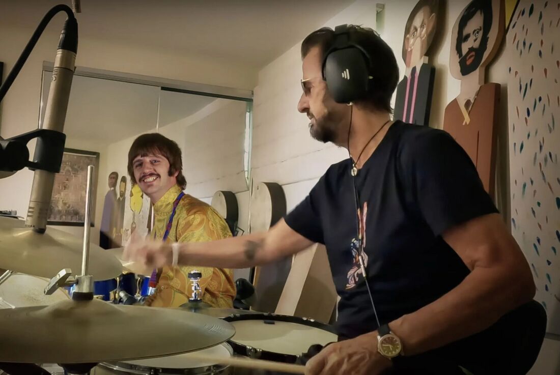 Ringo Starr plays drums with a steel watch on a dark strap visible on his left wrist.