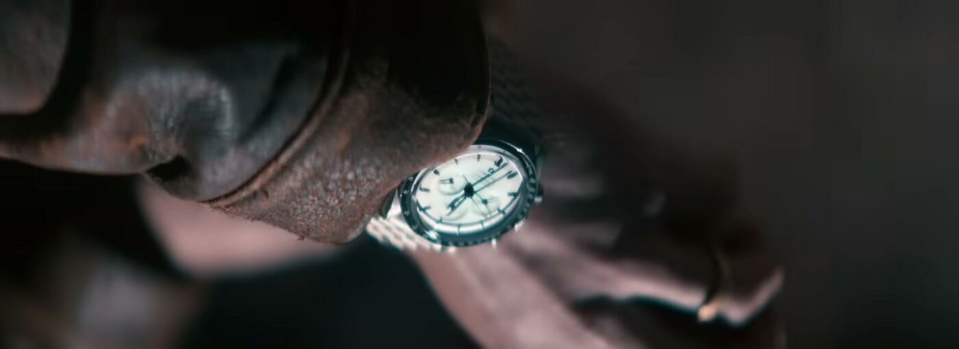 A pale-dial Speedmaster is visible beneath Nick Jonas’s dusty sleeve in Spaceman.