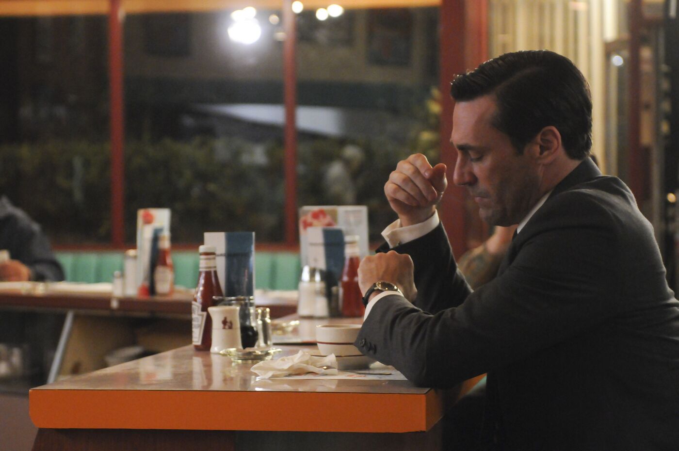 Don sits at a diner counter with a watch visible on his left wrist.