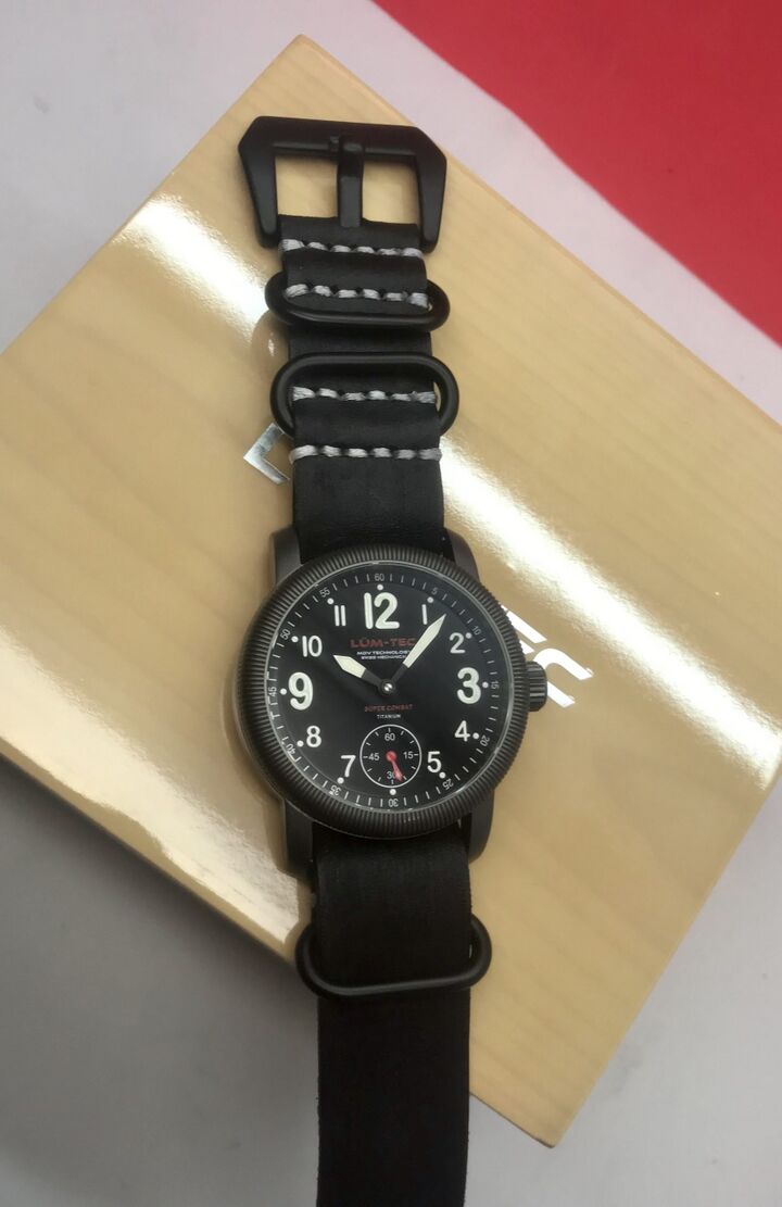 Dark Lüm-Tec watch on black leather, with large numerals, a ridged bezel and small seconds at six.