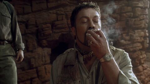 Tim Curry as Herkermer Homolka with the Unidentified 1970s gold tonneau dress watch in Congo (1995)