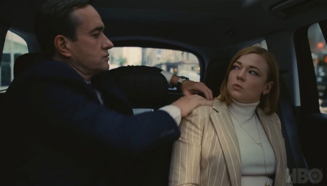 Tom reaches across to Shiv in a car, exposing his steel bracelet watch.